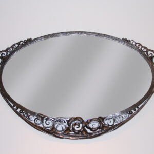An Art Deco forged iron oval mirror