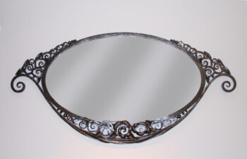 An Art Deco forged iron oval mirror