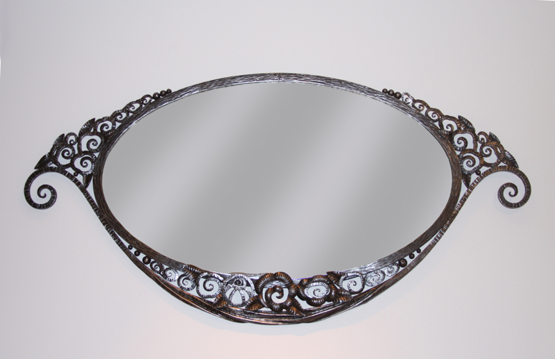 An Art Deco forged iron oval mirror