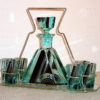 An unusual Art Deco cordial set bottle with stopper and six glasses on a silvered metal and glass ca