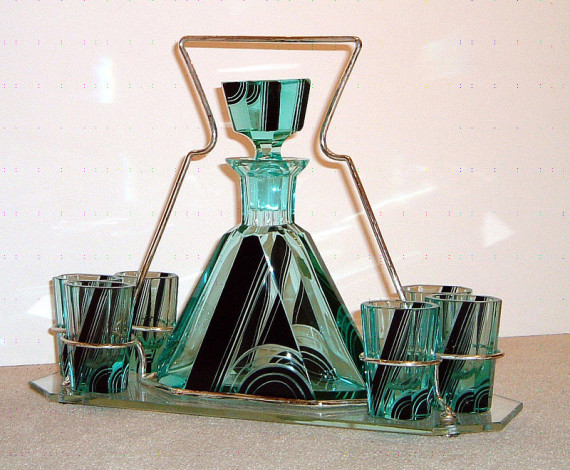 An unusual Art Deco cordial set bottle with stopper and six glasses on a silvered metal and glass ca