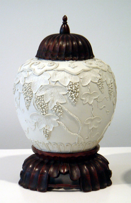 A fine pair of bisque overlay porcelain jars with rosewood covers and stands